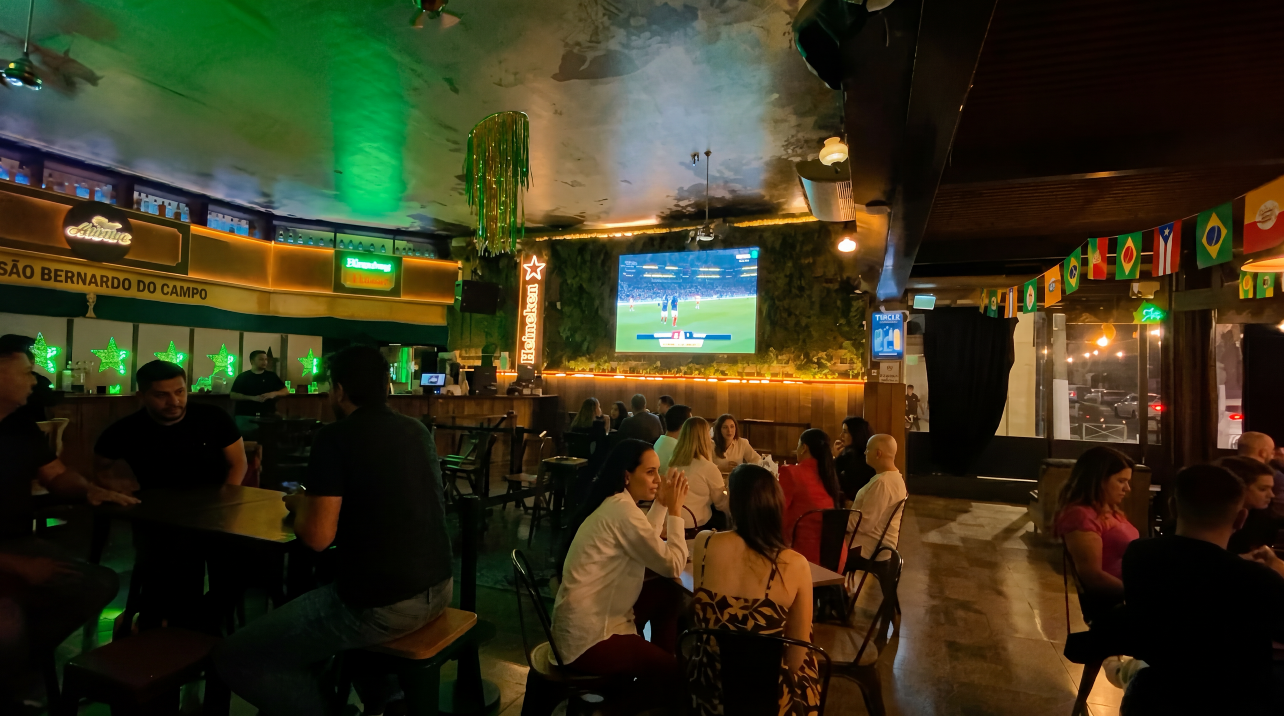 Clientes assistindo à transmissão no bar