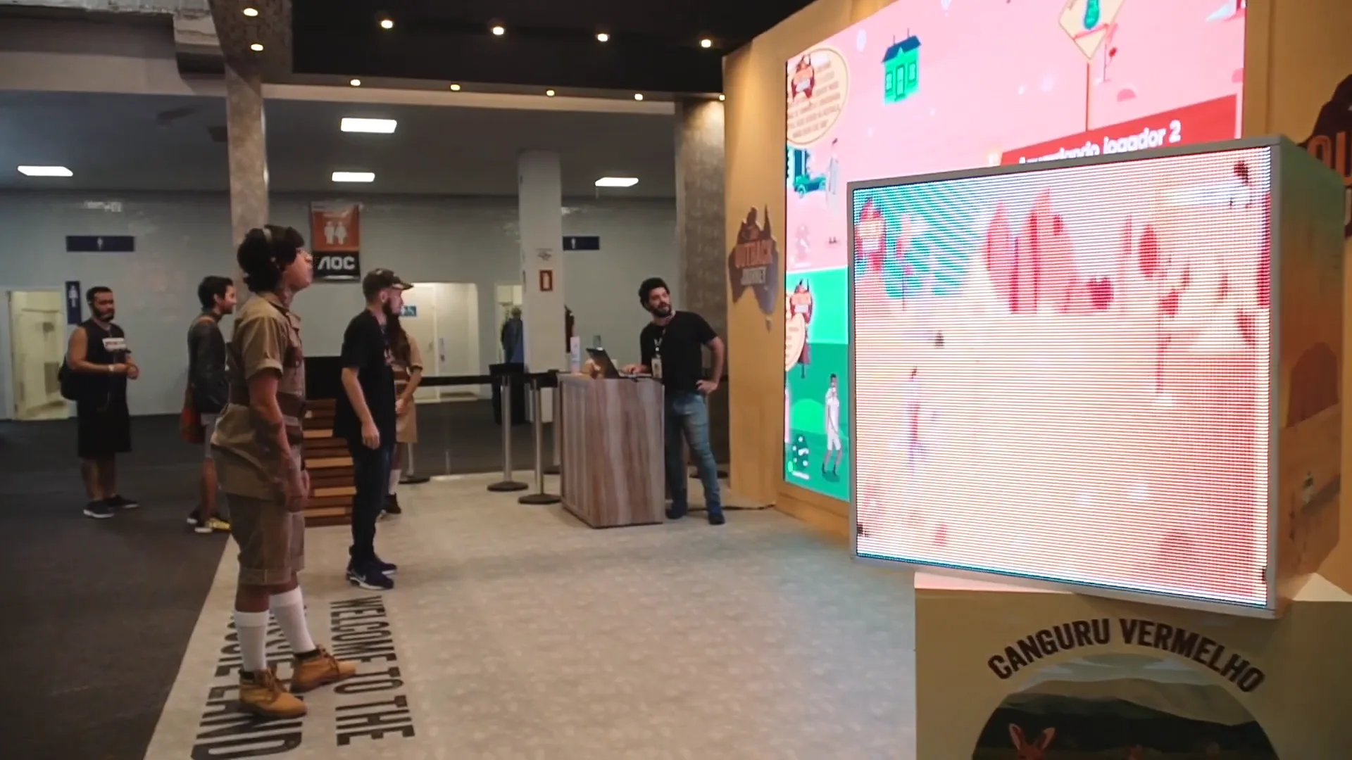 Visitante jogando em frente ao painel de LED da ativação